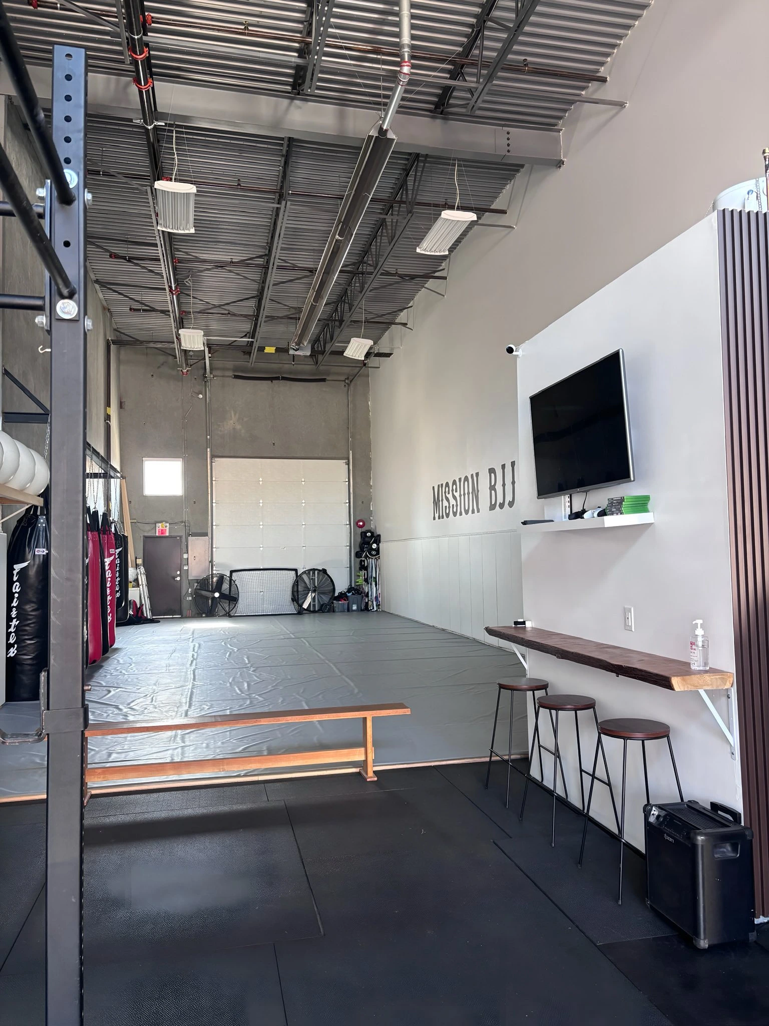 Barbell, kettlebell and rowing equipment in the strength annex at Mission BJJ